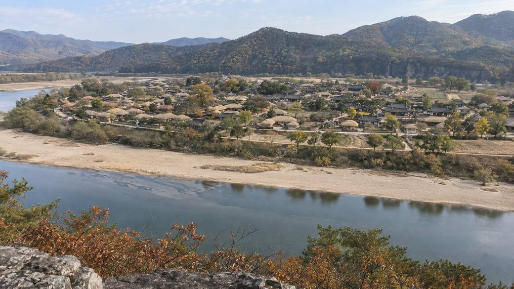 Hahoe Folk Village in Andong seen from the cliff across the Nakdong River, thatched and tiled roofs in a river bend on an
