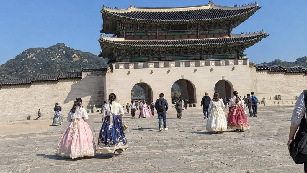 Gwanghwamun gate of Gyeongbokgung Palace with visitors in hanbok